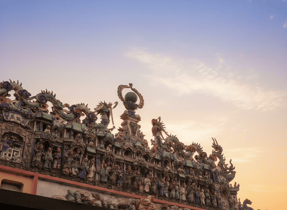 On the temple roof, prominent ceramic reliefs depict dragons, often the image of "two dragons fighting for a pearl" symbolizing nobility and power